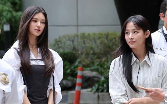 Members Danielle, left, and Minji of girl group NewJeans enter the Seoul Central District Court building in southern Seoul to attend a mediation session on Aug. 14. [NEWS1]