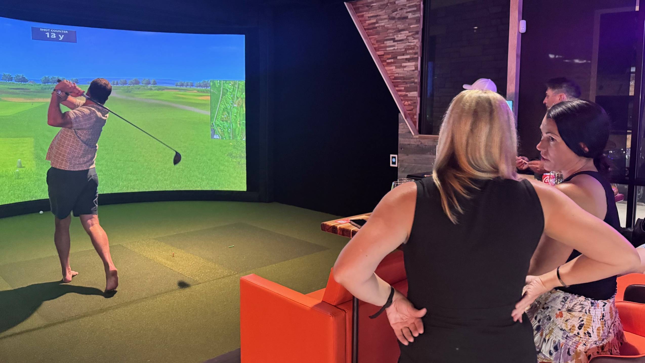 Men and women enjoying simulator golf
