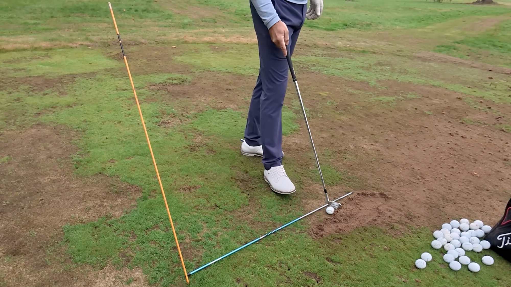 Hitting station used by Robert Rock when practicing his iron shots, using two alignment sticks for swing plane calibration