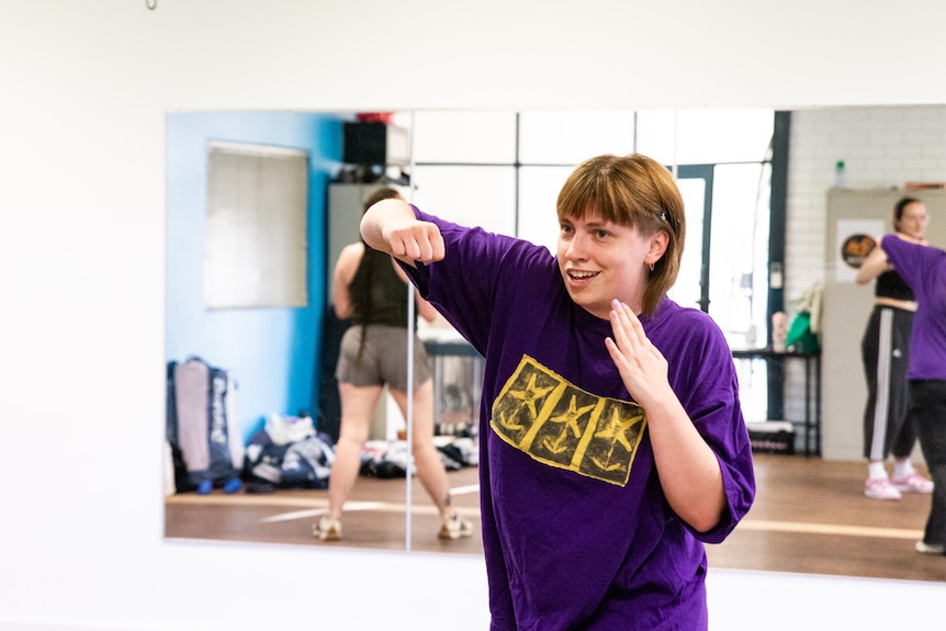 Participants smiling in a boxing class.