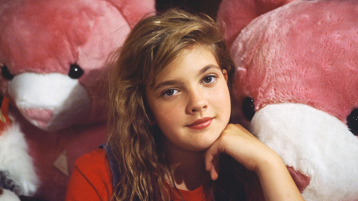 Drew Barrymore posing in front of pink bears.