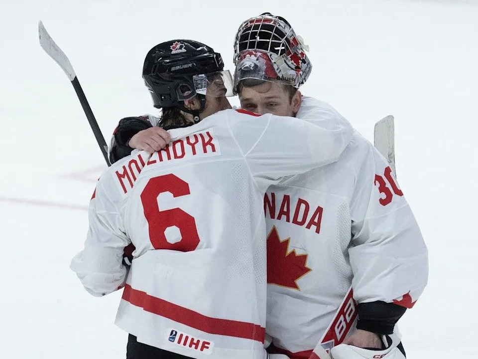Canadian defenceman Tanner Molendyk embraces teammate Carter George after 4-3 loss to Czechia in the tournament quarterfinals.