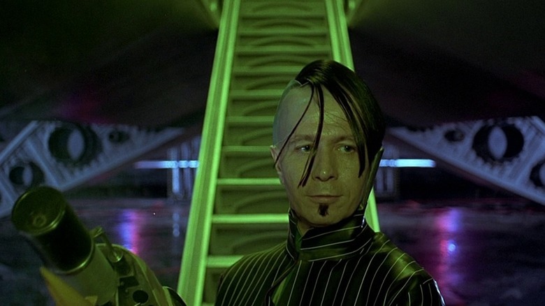 Gary Oldman as Zorg holding his gun at the bottom of the ramp to his ship in The Fifth Element