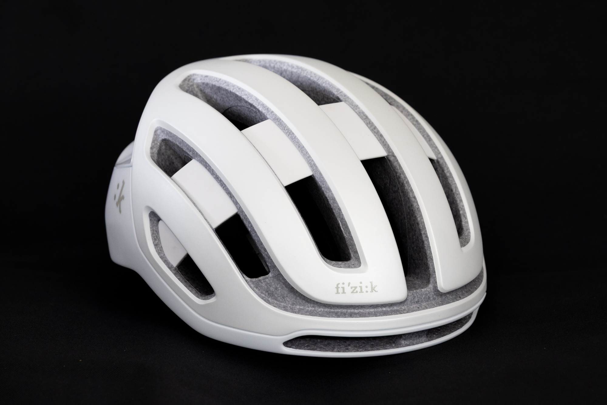 image shows a white Fizik Kudo road helmet against a black background