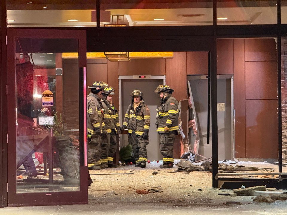 Firefighters survey the scene after a car crashed into the Explorer Hotel on December 24, 2025. Ollie Williams/Cabin Radio