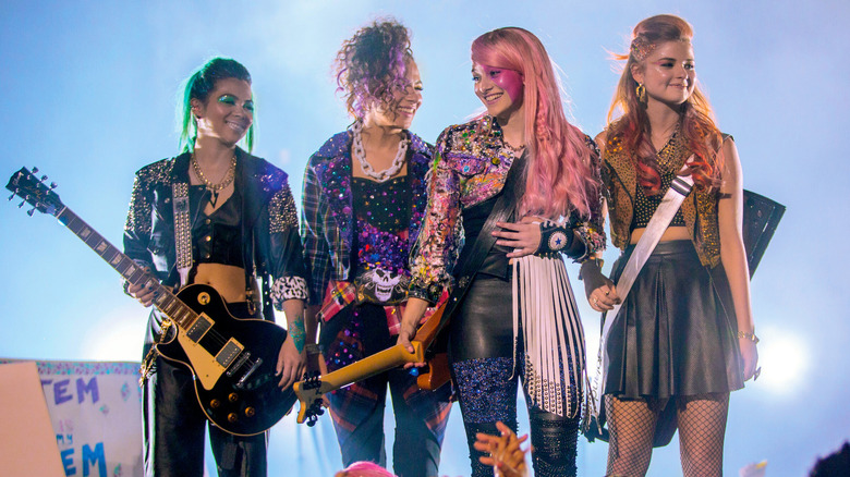 Jem and the Holograms smile together on stage in Jem and the Holograms