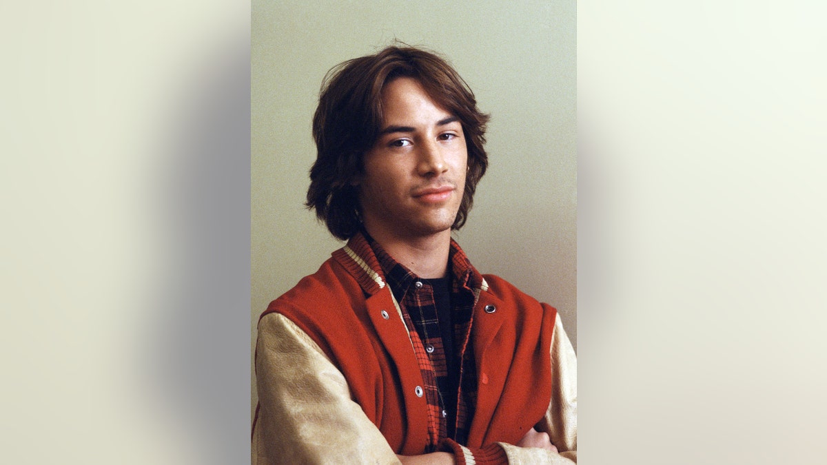 Keanu Reeves wearing a varsity jacket.