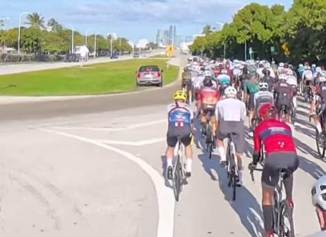 Mini driver overtakes group of cyclists on grass in Miami 