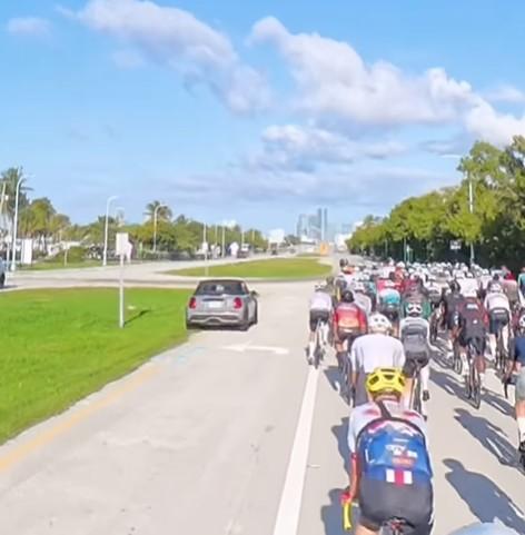 Mini driver overtakes group of cyclists on grass in Miami