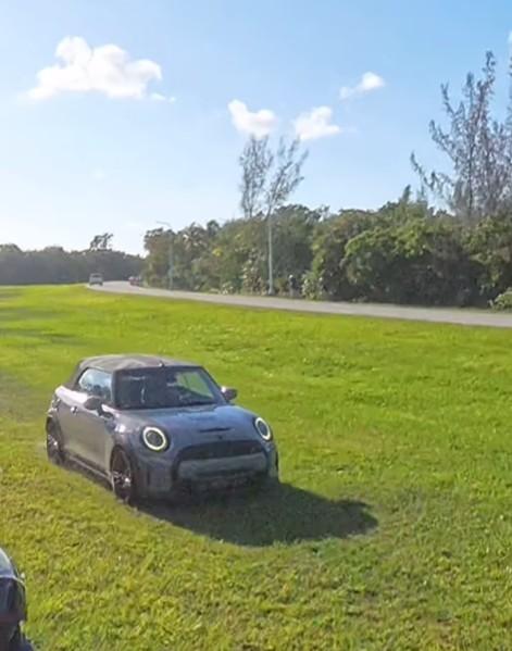 Mini driver overtakes group of cyclists on grass in Miami