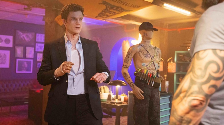 Jack Quaid as Nathan Caine facing off with a heavily-tattooed man in Novocaine