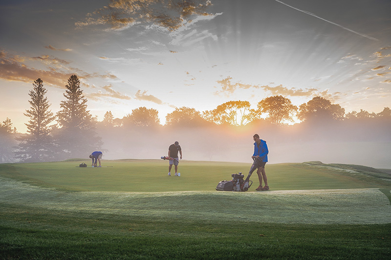 Early morning shot of a crew mowing a golf course.