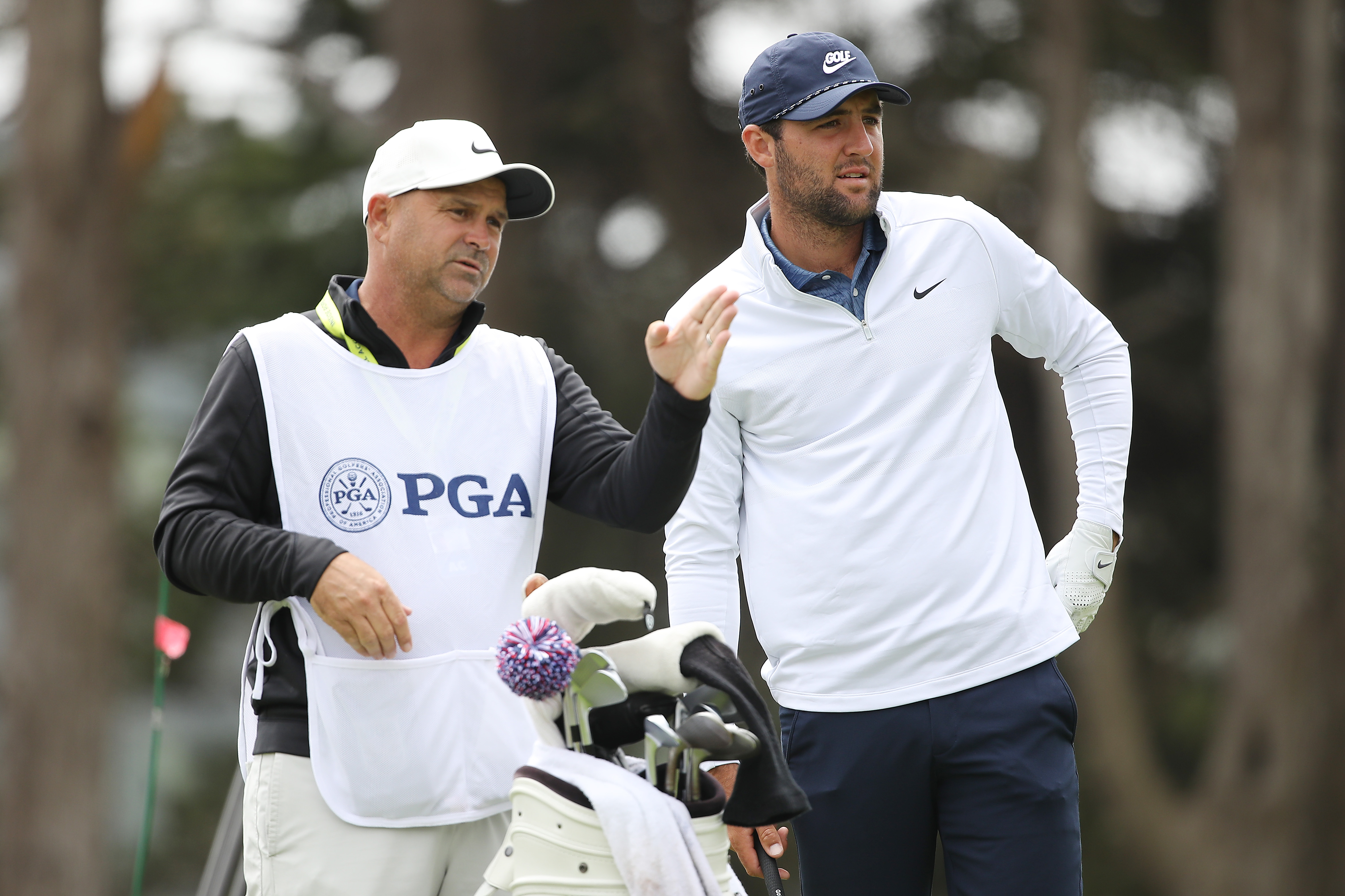 Scottie Scheffler speaks to his caddie