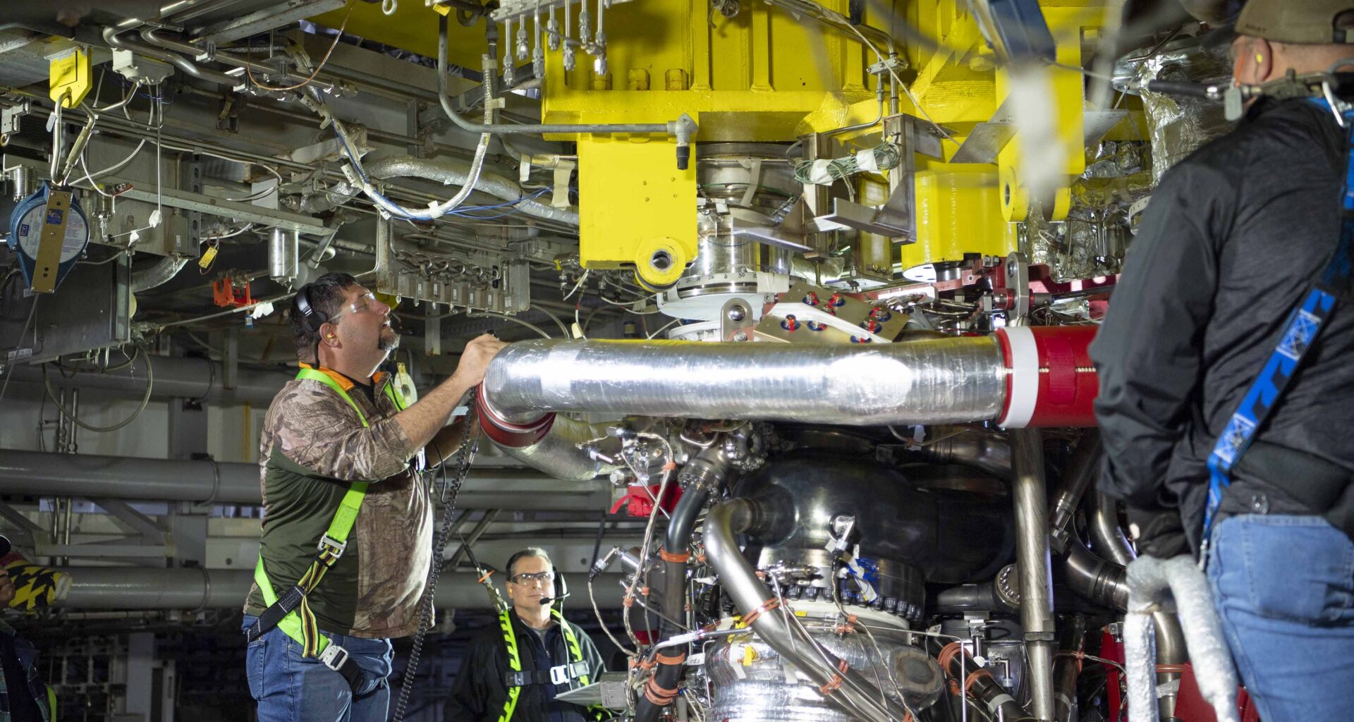 crew installing the first new production RS-25 engine on the Fred Haise Test Stand