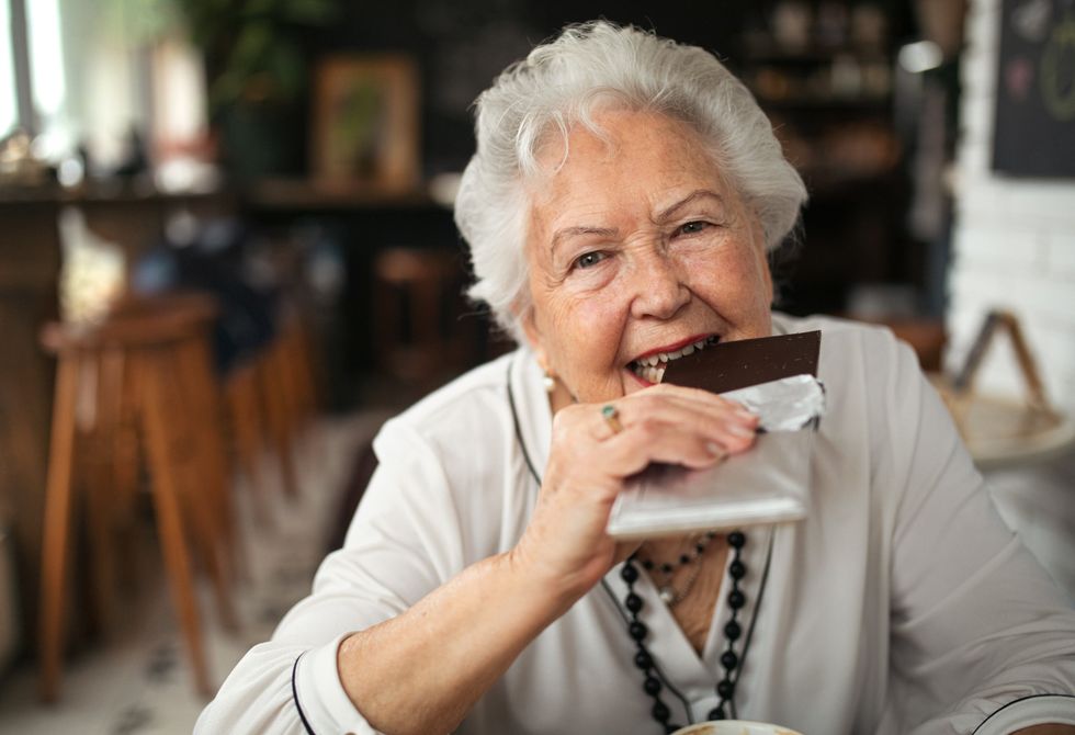 SENIOR WOMAN EATING CHOCOLATE