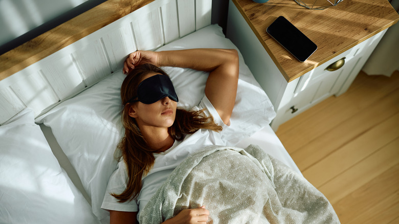 A woman in bed wearing a sleeping mask.