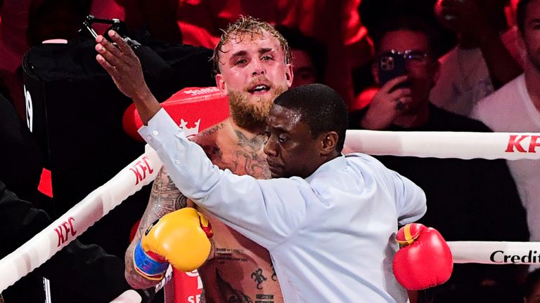Jake Paul is held back by the referee during the heavyweight bout against Anthony Joshua