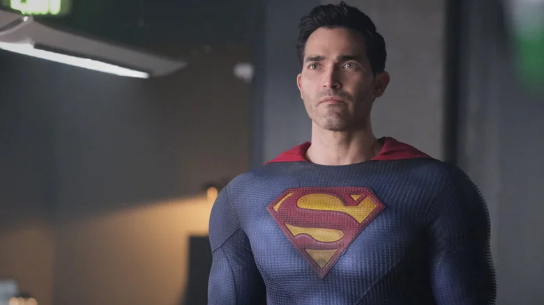 Superman (Tyler Hoechlin) stands sternly in a dimly lit room in Superman & Lois