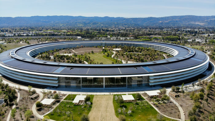 Aerial view of a large circular tech campus surrounded by greenery, symbolizing AI industry and its hidden challenges.