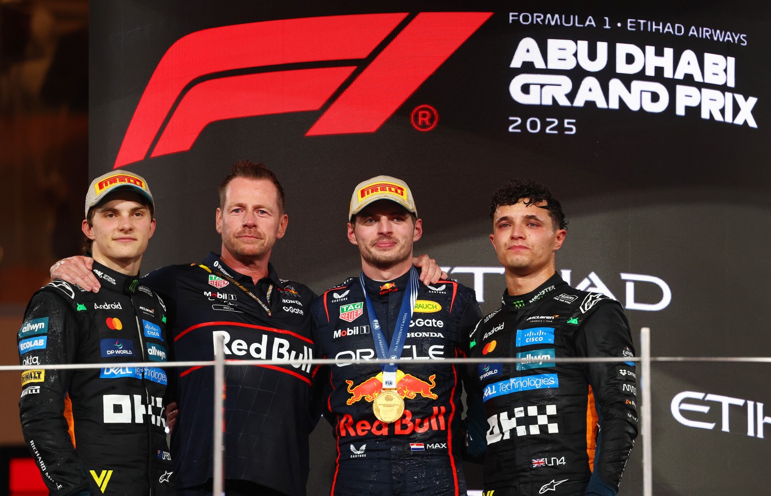 Race winner Max Verstappen of the Netherlands and Oracle Red Bull Racing Second placed Oscar Piastri of Australia and McLaren 2025 F1 World Drivers Champion and Third placed Lando Norris of Great Britain and McLaren and Richard Wolverson, Head of Racing Operations of Oracle Red Bull Racing on the podium during the F1 Grand Prix of Abu Dhabi at Yas Marina Circuit on December 07, 2025 in Abu Dhabi, United Arab Emirates. (Photo by Clive Rose/Getty Images) // Getty Images / Red Bull Content Pool //