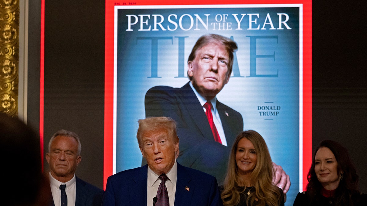 Donald Trump and others in front of image of Time's person of the year cover featuring Trump