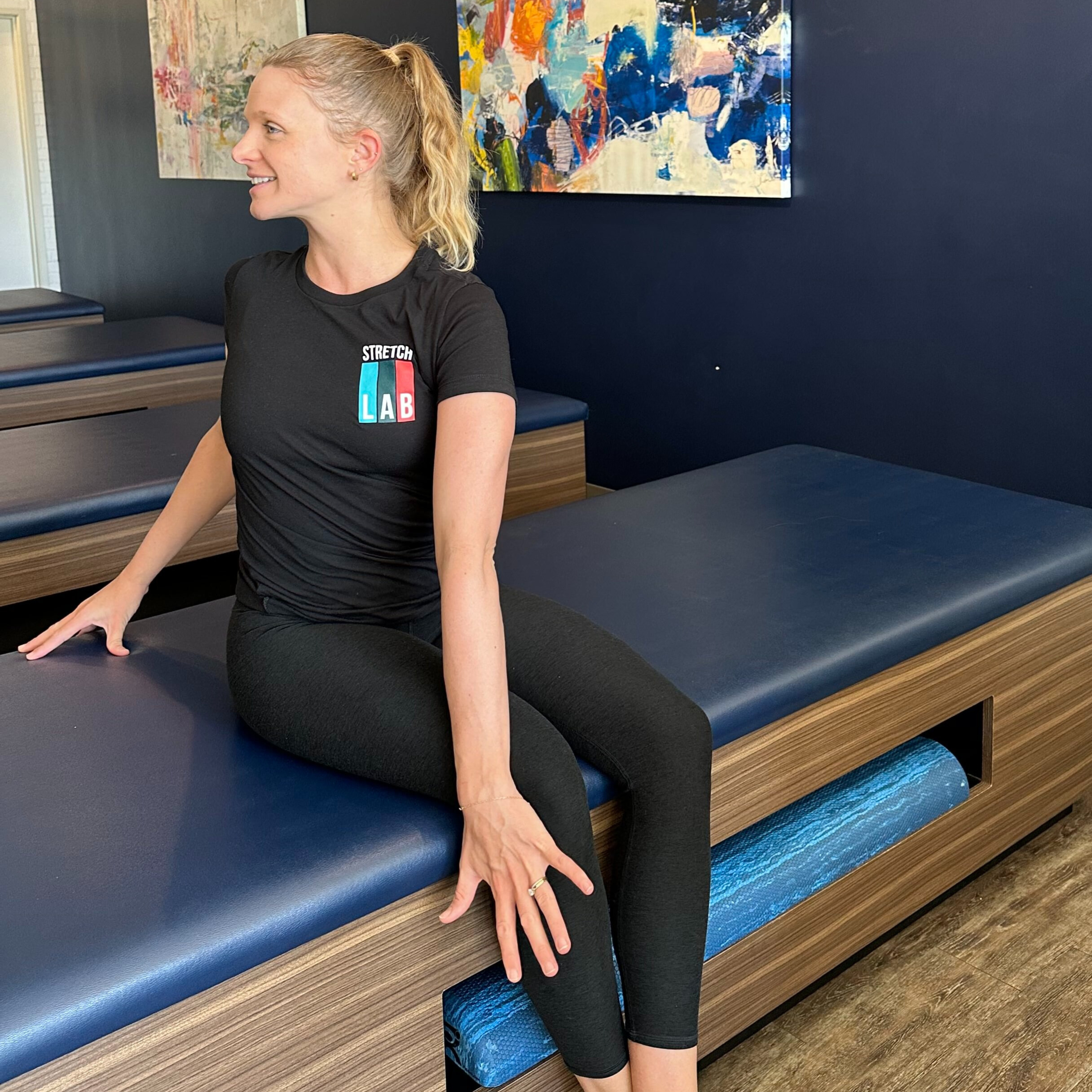 Woman demonstrates stretch in fitness studio