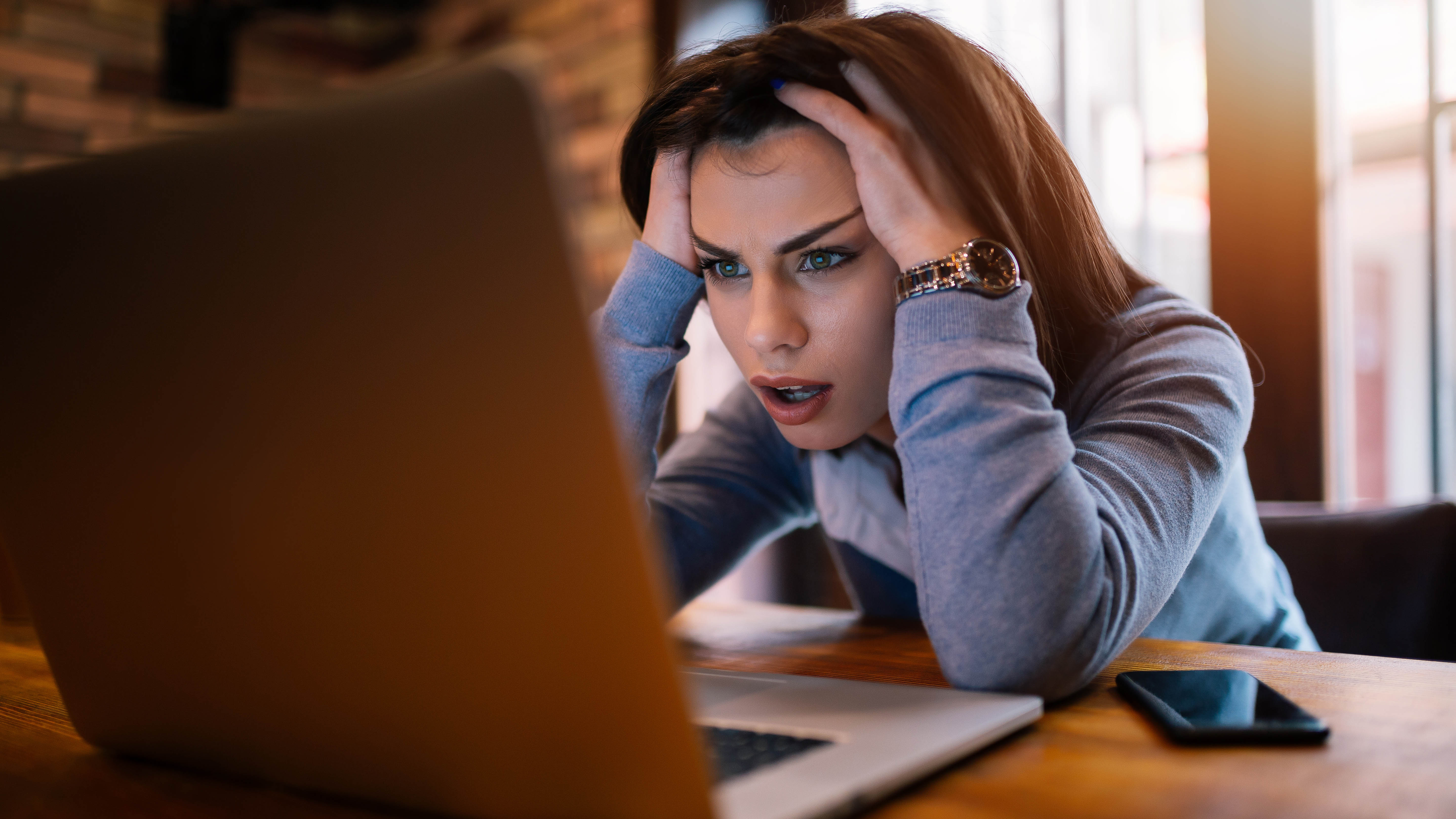 A woman sitting at her laptop looking frustrated
