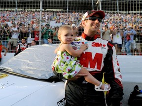 Greg Biffle holds his daughter, Emma, before a NASCAR Sprint Cup Series auto race at Atlanta Motor Speedway in 2012.