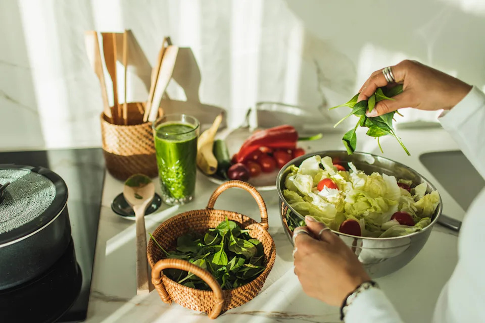 Woman mixing bowl of fresh salad. Copy space. Food and cook concept.