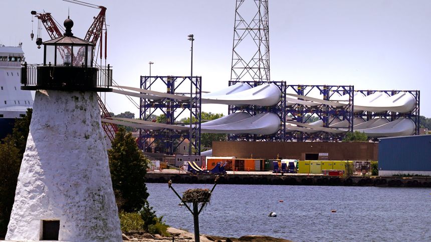 Giant wind turbine blades for the Vineyard Winds project are stacked on large racks in the harbor, on July 11, 2023, in New Bedford, Massachusetts.