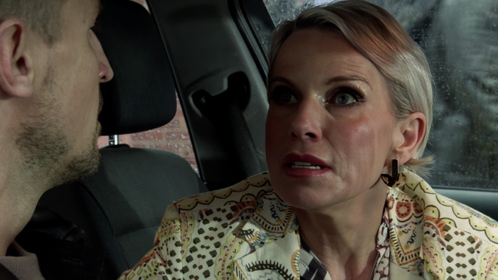 Debbie Webster looks stunned in a car in a scene from Coronation Street