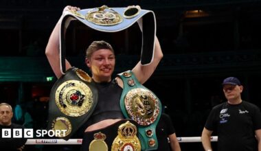Lauren Price holds her world title belts in the ring
