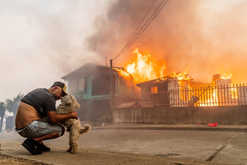 A member of the Gonzalez family pets his dog after the family's home caught fire.