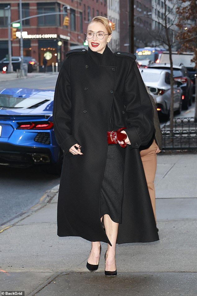 The mother-of-two, 29, wore thin-rimmed spectacles and an oversized black coat which had enhanced shoulders and giant epaulettes