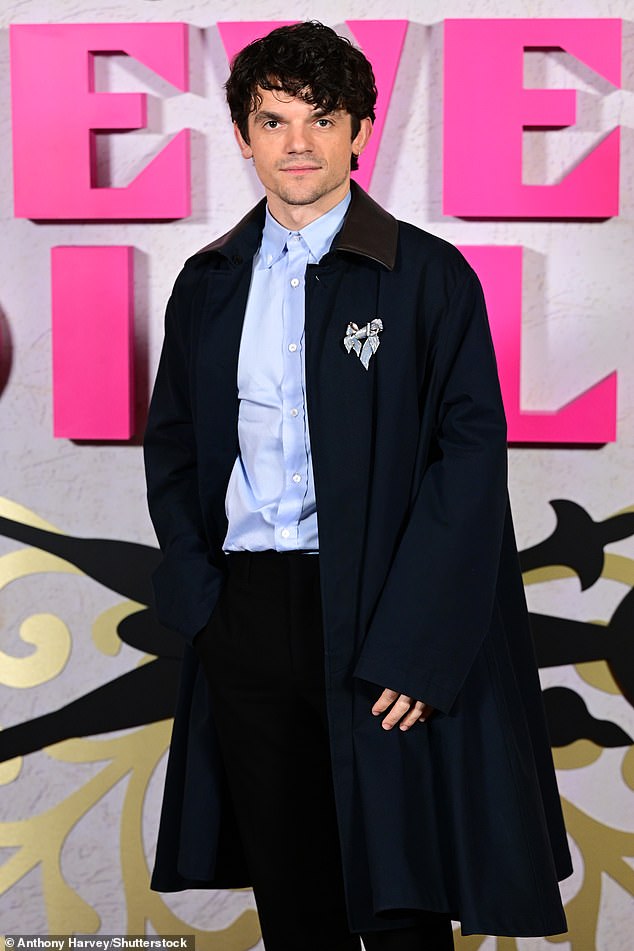 Edward Bluemel, who also stars in the series as Jimmy Thesiger, wore a striking navy cape coat over a pale blue shirt and black trousers