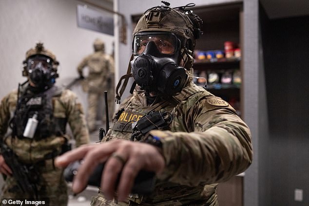 Federal agents enter the lobby after breaking up a protest outside a hotel in Minneapolis