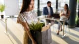 Sad female worker carrying her belongings while leaving the office after being fired