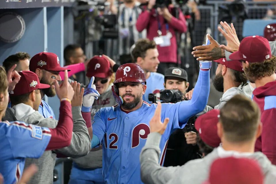 Oct 8, 2025; Los Angeles, California, USA; Philadelphia Phillies designated hitter Kyle Schwarber (12) celebrates in the dugout after hitting a solo home run during the fourth inning against the Los Angeles Dodgers during game three of the NLDS round for the 2025 MLB playoffs at Dodger Stadium. Mandatory Credit: Jayne Kamin-Oncea-Imagn Images
