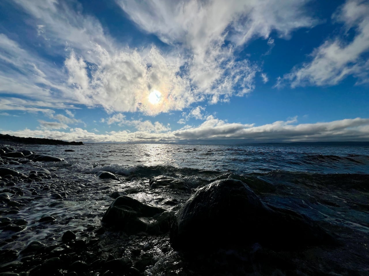 Rocks on the beach with blue sky and clouds