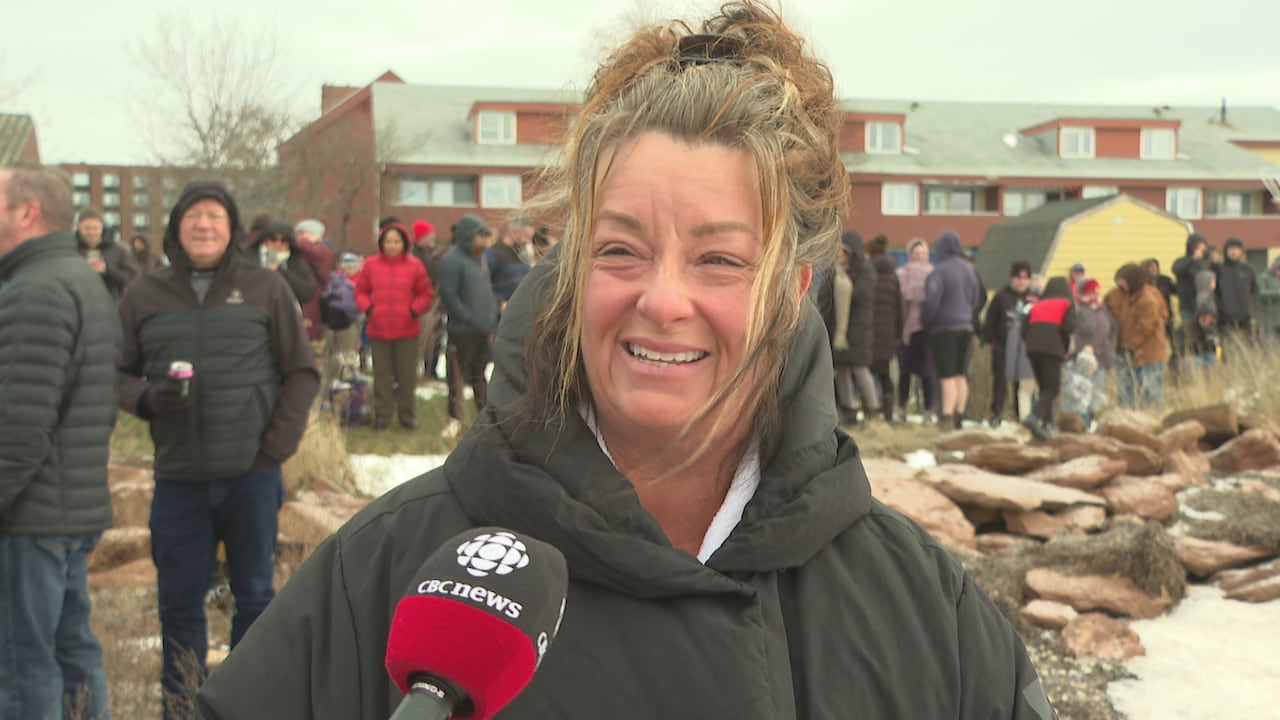 Woman with CBC mircophone talks about participating in the Polar Bear Dip.