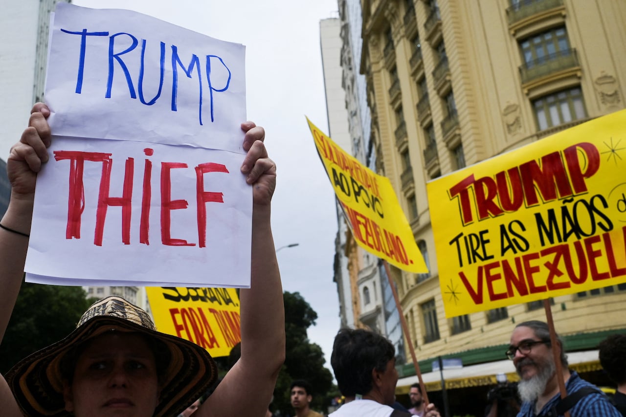 Placards are held aloft at a protest in Brazil, showing opposition to U.S. strikes in Venezuela