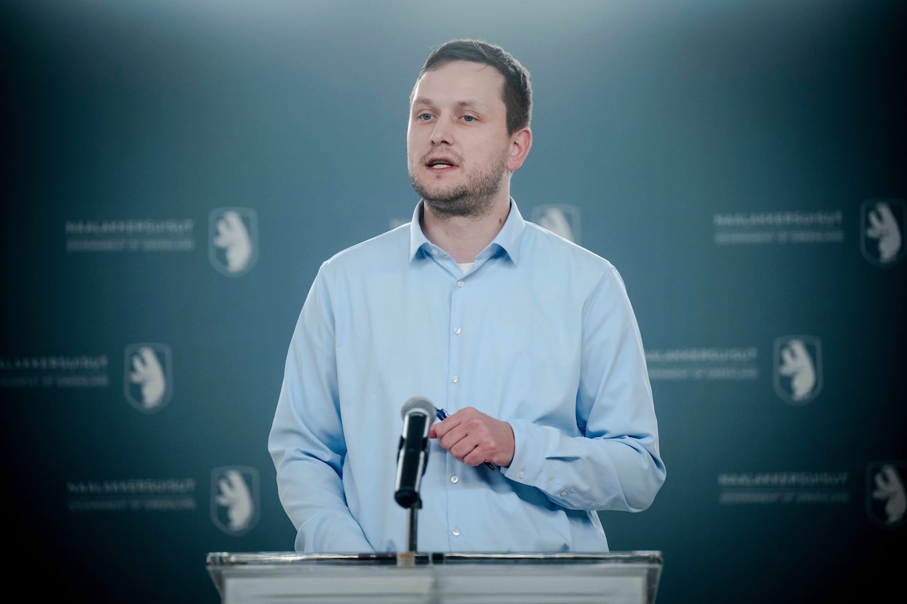 A man speaks at a lectern.