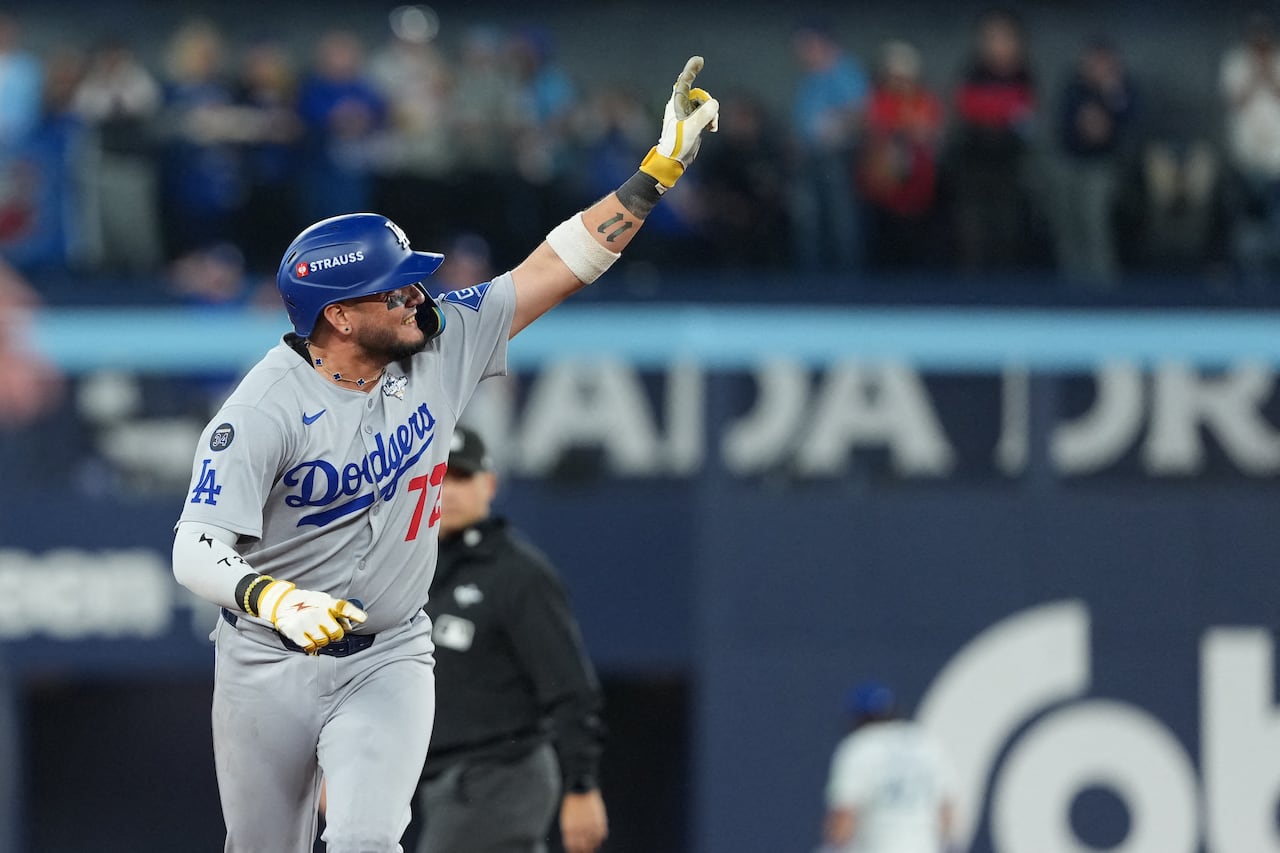 A baseball player celebrates a home run, while circling the bases 