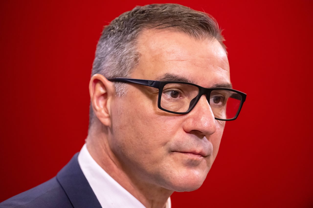 A hockey team executive listens during a news conference.