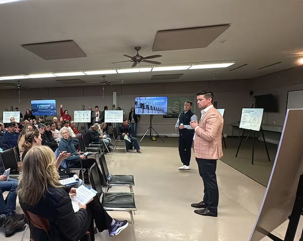 Man speaking in front of an audience. 