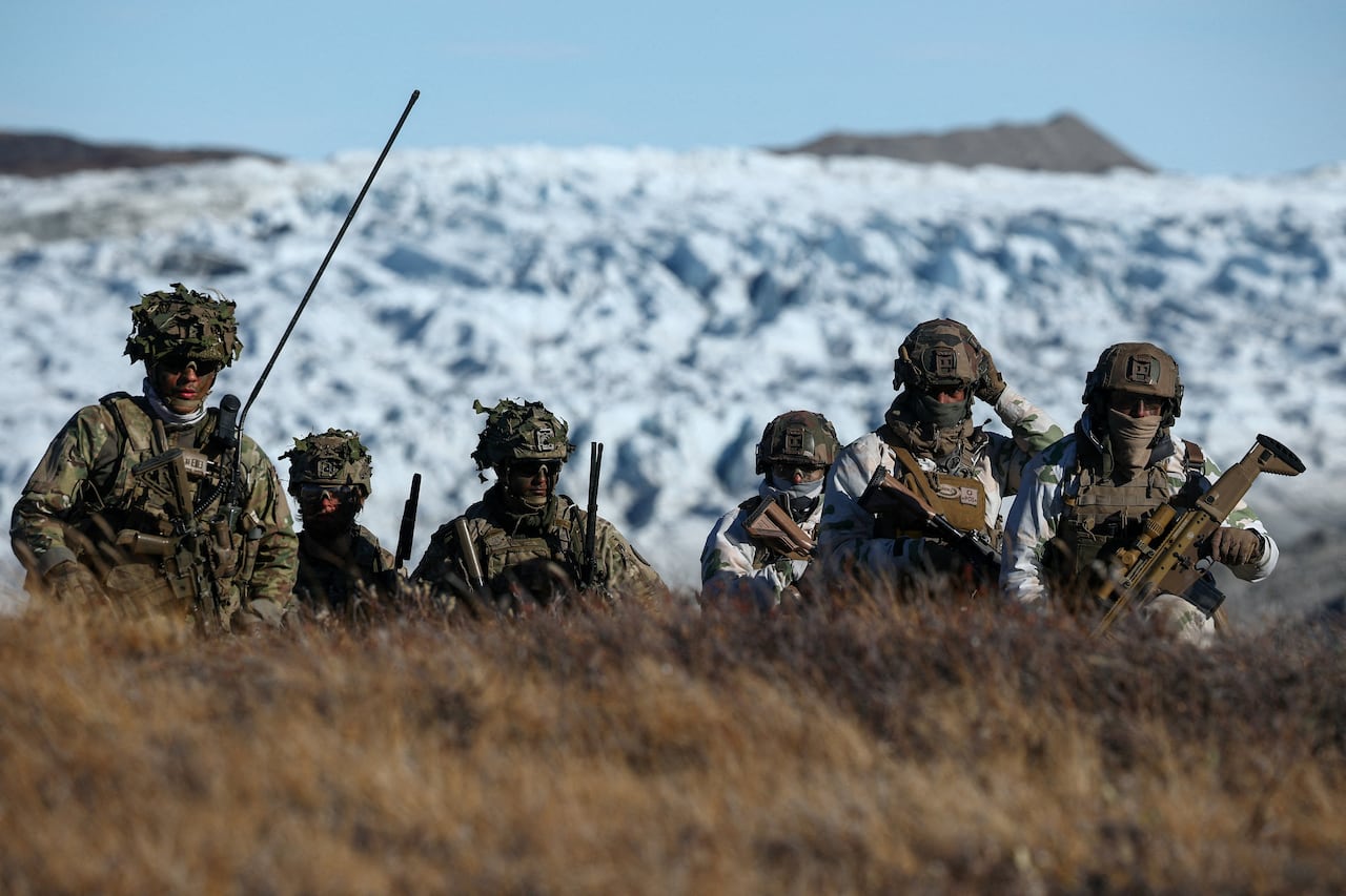 Soldiers seen in camouflage outside.