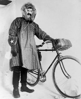 A man in a parka poses with a bike