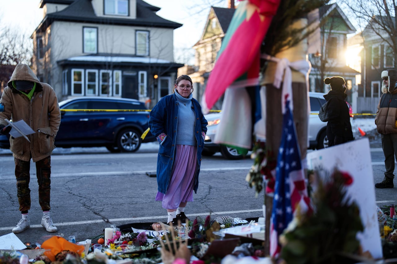 A tearful woman stands in front of a display of flowers