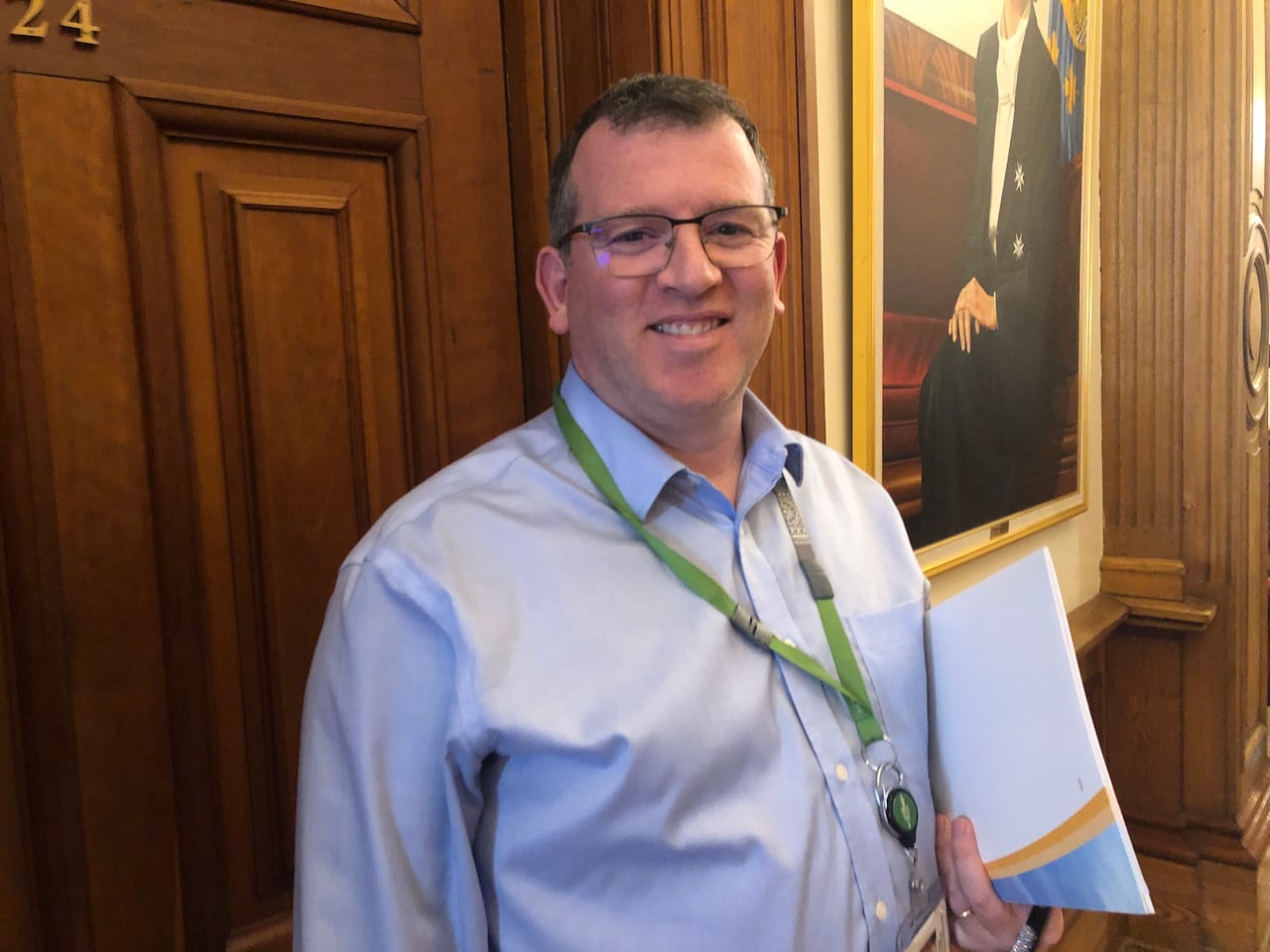 A man wearing glasses smiles.