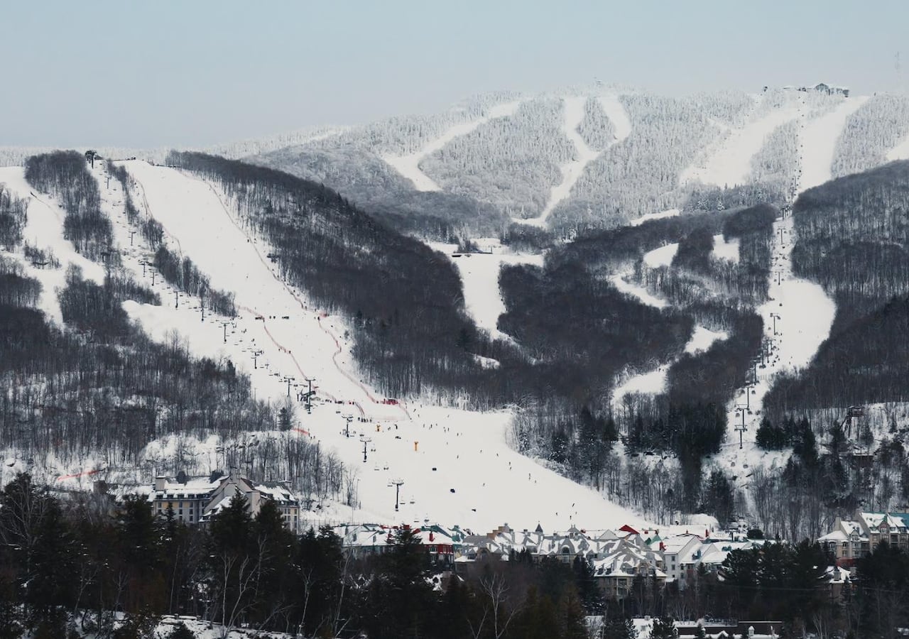 A ski mountain with ski runs visible covered in snow